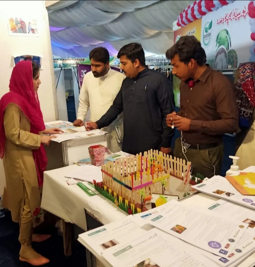 people talking at an agriculture show booth